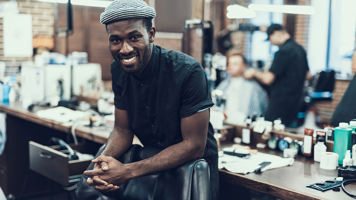 Charming hairdresser smiling and looking in camera